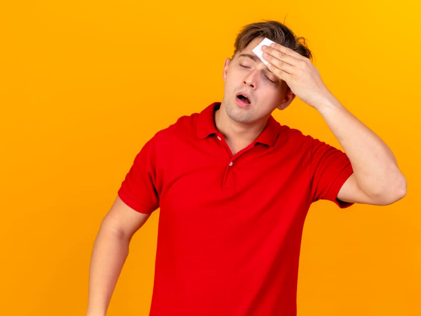 Weak-young-handsome-blonde-ill-man-wiping-sweat-with-closed-eyes-isolated-on-orange-background.jpg