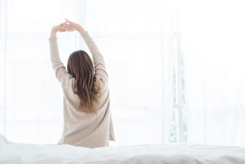 Back-view-of-happy-beautiful-young-asian-woman-waking-up-in-morning-sitting-on-bed.jpg