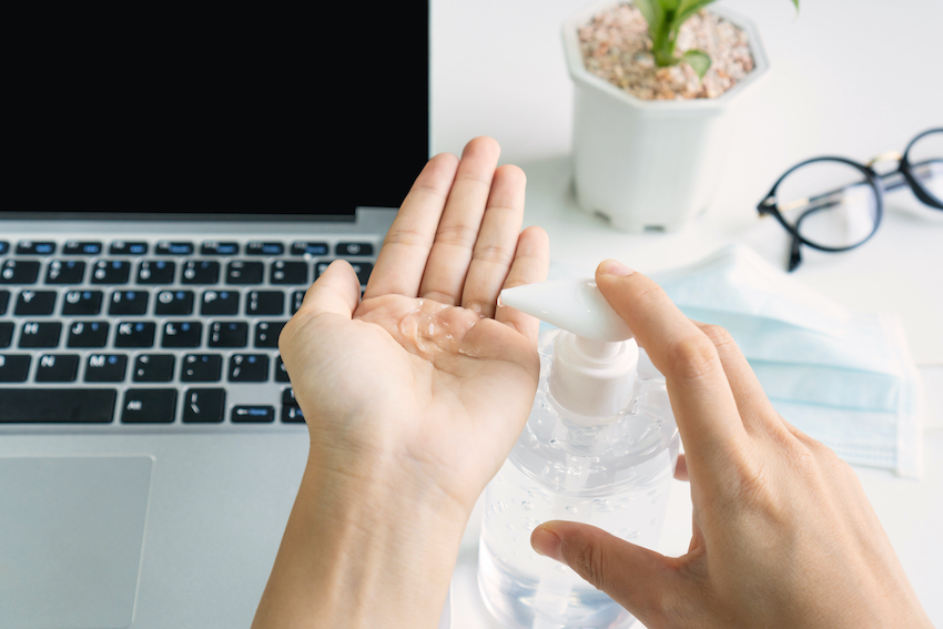 Hands-using-a-disinfectant-in-front-of-the-computer.jpg