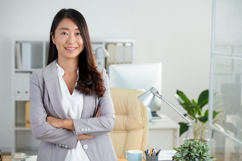Cheerful-korean-business-lady-posing-in-office-with-crossed-arms.jpg