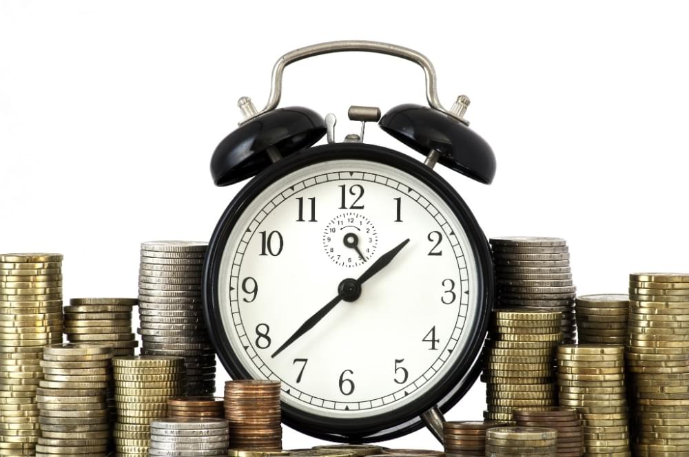 20220807_time-is-money-concept-alarm-clock-and-lots-of-euro-coins.jpg