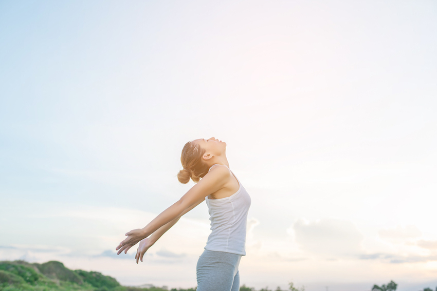 Concentrated-woman-stretching-her-arms-with-sky-background.jpg