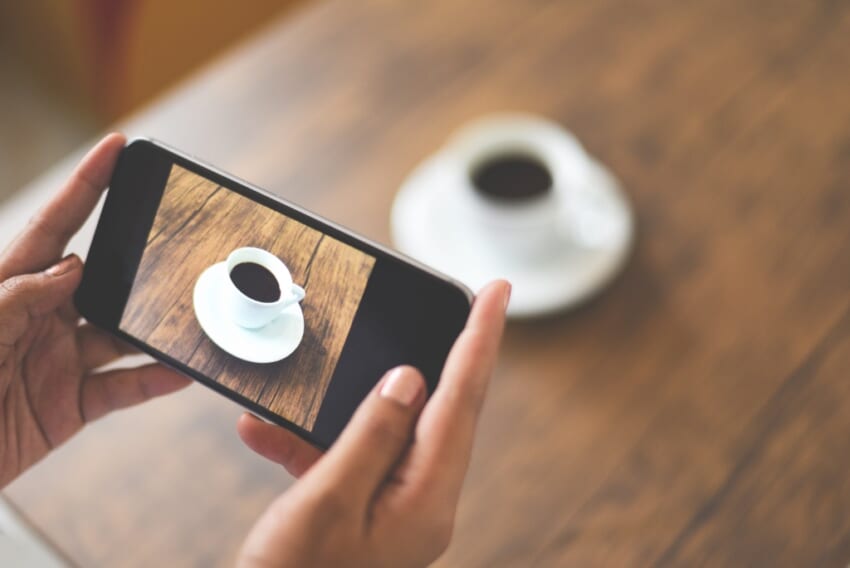 20221219_taking-photo-coffee-cup-with-camera-smartphone-for-use-technology-post-upload-file-to-online-on-internet-close-up-of-woman-hand-holding-mobile-phone-photographing-coffee-cup-on-wooden-table.jpg