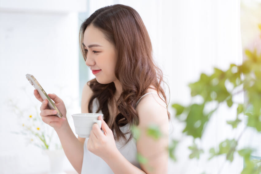 Young-asian-woman-using-smartphone-at-home-in-the-morning.jpg
