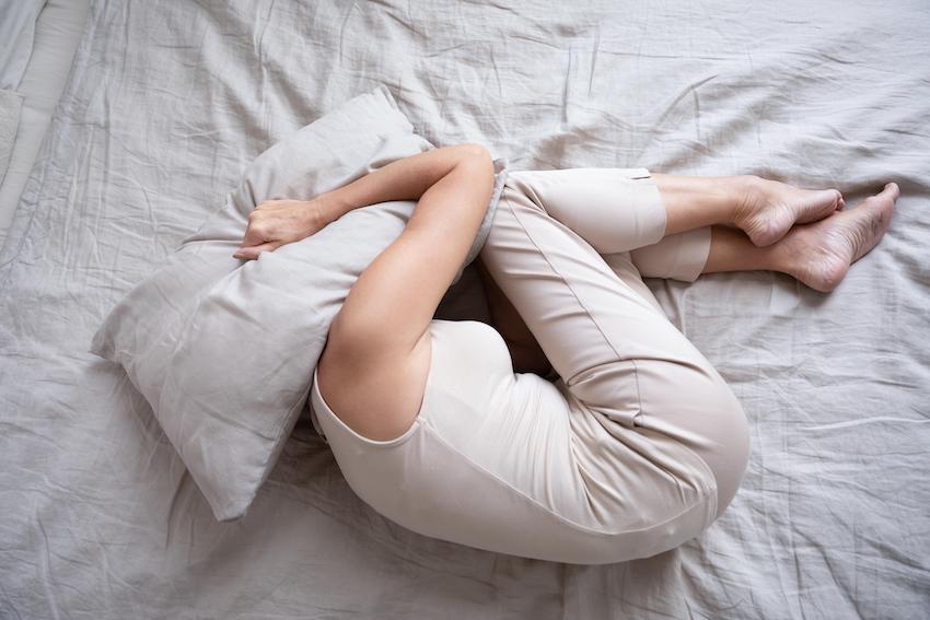 Frightened-depressed-middle-aged-woman-lying-alone-on-bed-in-fetal-position-covering-head-with-pillow-feeling-afraid-or-depressed-suffer-from-insomnia-mental-problem-abuse-violence-concept-top-view.jpg