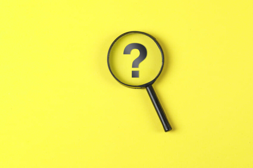 Business-and-financial-concept-with-magnifying-glass-question-mark-on-yellow-background-flat-lay.jpg