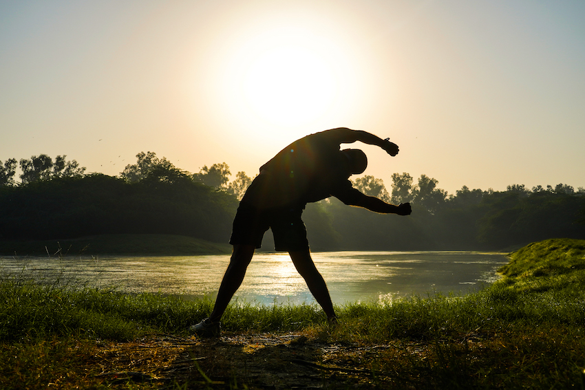 Silhouette-of-a-boy-doing-exercises-in-park-near-sun-and-river-health-concept.jpg