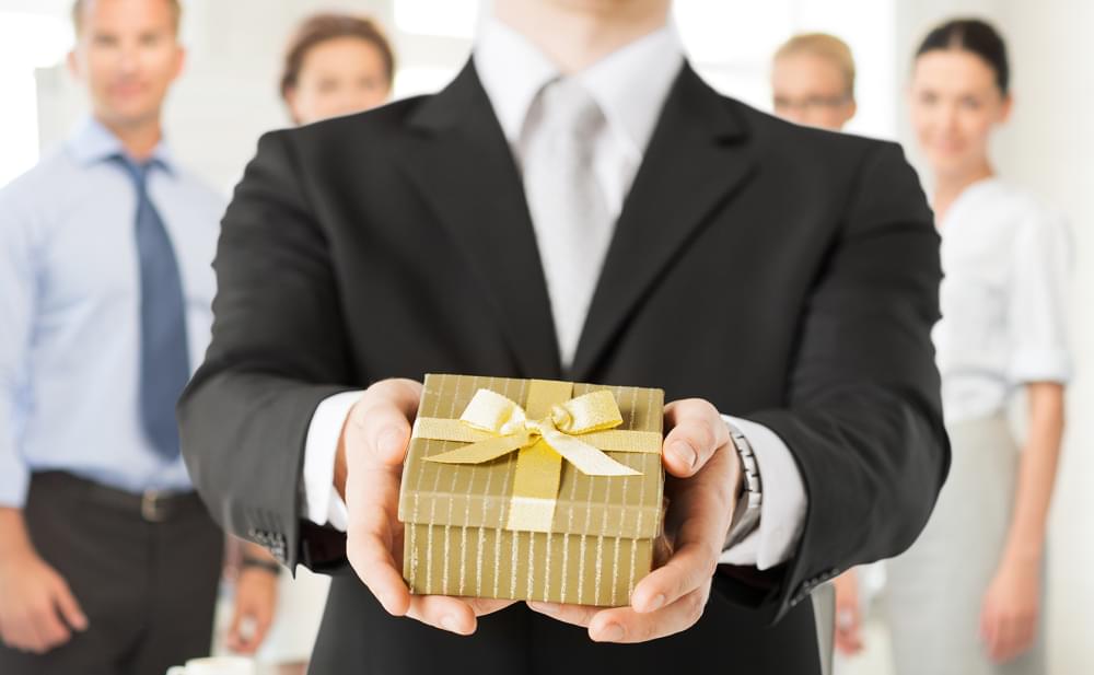Close-up-of-man-hands-holding-gift-box-in-office_image.jpg