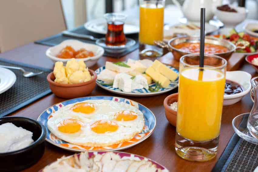 Front-view-breakfast-table-with-eggs-buns-cheese-fresh-juice-restaurant-daytime-food-meal-breakfast.jpg