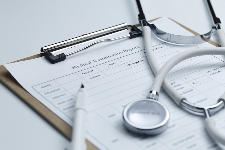 Medical-examination-report-stethoscope-white-desktop.jpg
