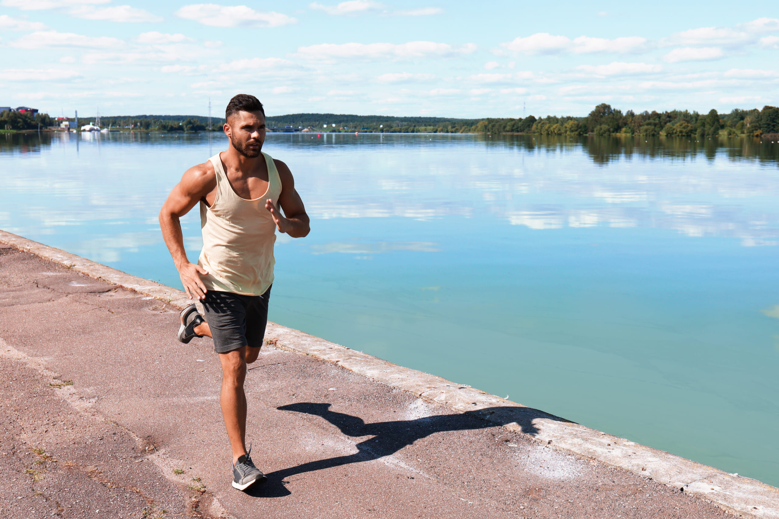 Strong-sport-man-jogging-while-working-out-near-city-riverfront.jpg